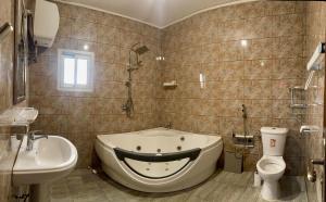 a bathroom with a tub and a toilet and a sink at L Arche in Douala
