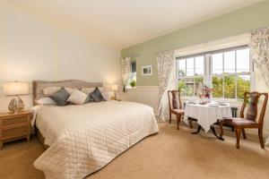 a bedroom with a bed and a table and a window at Grange Manor in Grange Over Sands
