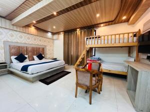 a bedroom with two bunk beds and a desk at YogMaya Regency in Shimla