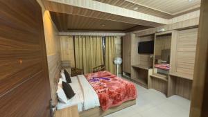 a bedroom with a bed and a television in it at YogMaya Regency in Shimla