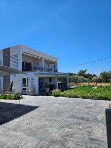 a large white house with a large driveway at Like home in Samothraki 2 in Kamariotissa