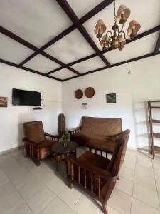 a living room with chairs and a couch and a tv at Hotel Jardin de la Paix in Moroni