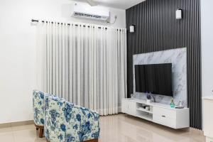 a living room with a chair and a television at Inverse Travels in Negombo