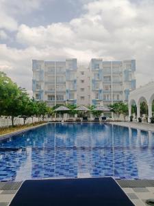 a large swimming pool in front of a large building at Inverse Travels in Negombo