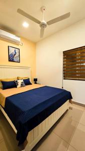 a bedroom with a blue bed with a ceiling fan at Inverse Travels in Negombo +5 photos