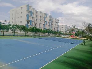 a tennis court in front of a large building at Inverse Travels in Negombo