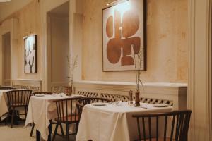 a dining room with tables with white tablecloths at Hydro Hotel in Lisdoonvarna +37 photos