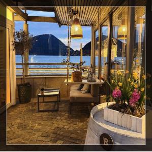 a room with a view of the water and a table at Dimora di Aida Lugano Lake in Porlezza