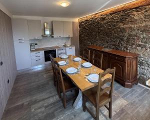a dining room with a wooden table and a kitchen at Il Ranch in Baveno
