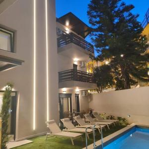 a villa with a swimming pool at night at 7 Suites in Skiathos