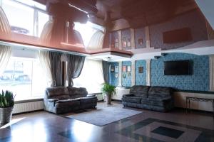 ein Wohnzimmer mit zwei Sofas und einem Fernseher in der Unterkunft Cherkasy Palace in Tscherkassy