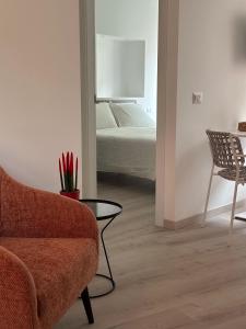 a living room with a chair and a bed at Dimora di Aida Lugano Lake in Porlezza