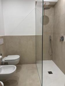 a bathroom with a toilet and a glass shower at Dimora di Aida Lugano Lake in Porlezza +6 photos