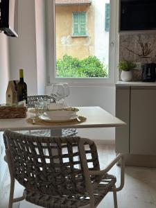a table and a chair in a kitchen with a window at Dimora di Aida Lugano Lake in Porlezza