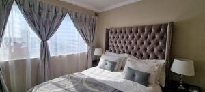 a bedroom with a large bed and a window at Beach Apartment in Durban in Amanzimtoti