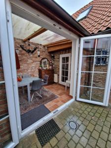 an open patio with a table and a glass door at Hexenhaus in Lüneburg