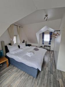a bedroom with a large bed with white sheets at Hexenhaus in Lüneburg