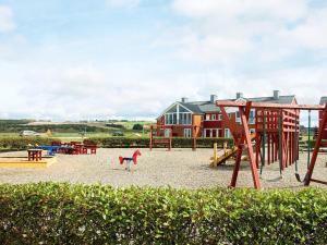 a playground with a slide and a swing set at 5 person holiday home on a holiday park in Lemvig in Lemvig
