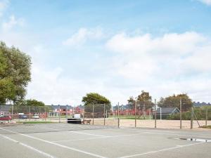 an empty tennis court with a fence and a tennis court at 5 person holiday home on a holiday park in Lemvig in Lemvig