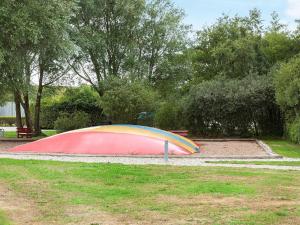 a rainbow colored object in a park with a bench at 5 person holiday home on a holiday park in Lemvig in Lemvig