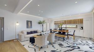 a living room with a table and a couch at 3 Muses Luxury Villas in Kalamaki