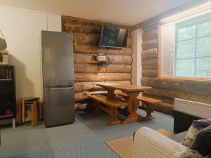 a living room with a table and a refrigerator at Revontuli 6 in Syöte