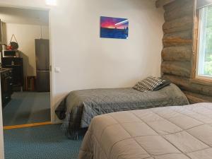 a bedroom with two beds and a stone wall at Revontuli 6 in Syöte