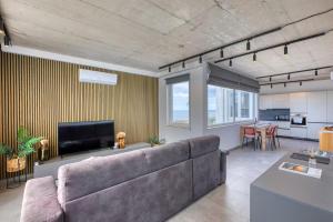 a living room with a couch and a television at Heated Private Jacuzzi Penthouse Breathtaking Seaview in Pembroke