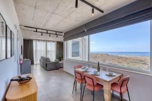 a dining room with a table and chairs and the ocean at Heated Private Jacuzzi Penthouse Breathtaking Seaview in Pembroke