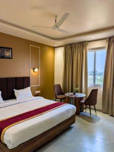 a hotel room with a bed and a table and chairs at Hotel Aashiyana in Shahdol +44 photos