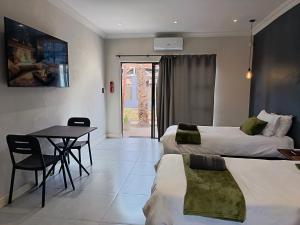 a room with two beds and a table and a dining room at Unit 7 Dinas Accommodation Oranjemund in Oranjemund