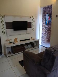 a living room with a couch and a flat screen tv at Hostel do Gui in Alto Paraíso de Goiás