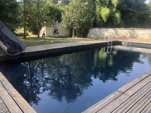 a swimming pool with a wooden deck and water at chambre INNAMORATO avec jacuzzi lit rond et jardin avec piscine in Saint-Martial-sur-Né +4 photos