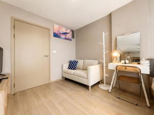 a living room with a chair and a desk and a mirror at Spacious Studio Near BTS Kitchen & Washer in Amphoe Phra Khanong