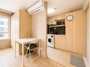 a small kitchen with a desk and a microwave at Spacious Studio Near BTS Kitchen & Washer in Amphoe Phra Khanong