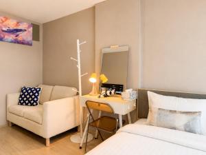 a bedroom with a bed and a desk and a chair at Spacious Studio Near BTS Kitchen & Washer in Amphoe Phra Khanong +16 photos