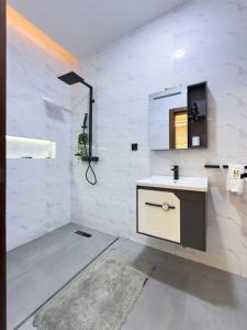 a white bathroom with a sink and a mirror at Luxury Balcony Apartment at THE HIDDEN DOMUS I Prestige Apartment in Accra +16 photos