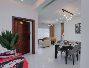 a living room with a table and a dining room at Luxury Balcony Apartment at THE HIDDEN DOMUS I Prestige Apartment in Accra
