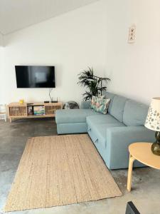 a living room with a blue couch and a flat screen tv at Casa d´Abela in Abela