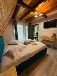 a large bed in a room with wooden ceilings at Complex Turistic Hor'A in Slănic +76 photos