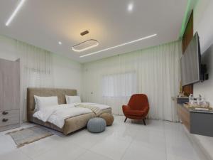 a bedroom with a bed and a red chair at Luxury Balcony Apartment at THE HIDDEN DOMUS I Prestige Apartment in Accra