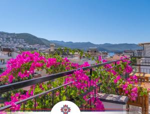 a bunch of pink flowers on a balcony at meltem pansiyon in Kaş
