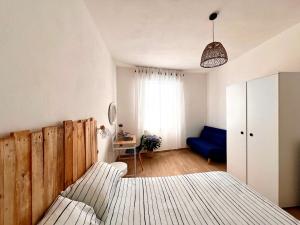 a bedroom with a bed and a blue couch at Cussorgia's House in Calasetta