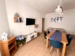 a living room with a dining room table and a kitchen at Cussorgia's House in Calasetta