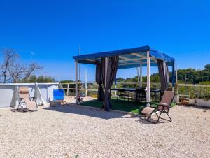 a gazebo with chairs and a picnic table at Villa with Sea View Parking in Lapedona