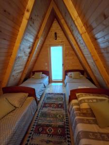 a attic room with four beds and a couch at Domaćinstvo braća Rebić in Gacko