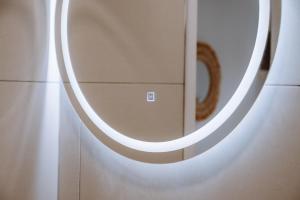 a circular mirror on a wall in a bathroom at Burano Camping Beach-Bar in Néa Thésis