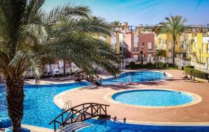 a pool with palm trees and buildings in the background at Vera dream Las Marinas LAGUNA BEACH in Vera