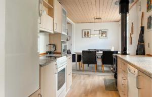 a kitchen with white cabinets and a dining room at 3 Bedroom Pet Friendly Home In Roslev in Roslev