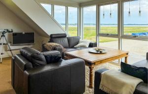 a living room with couches and a table and a television at 3 Bedroom Pet Friendly Home In Roslev in Roslev